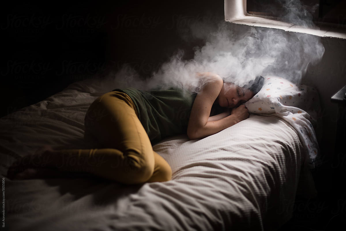Conceptual portrait of woman dreaming on bed
