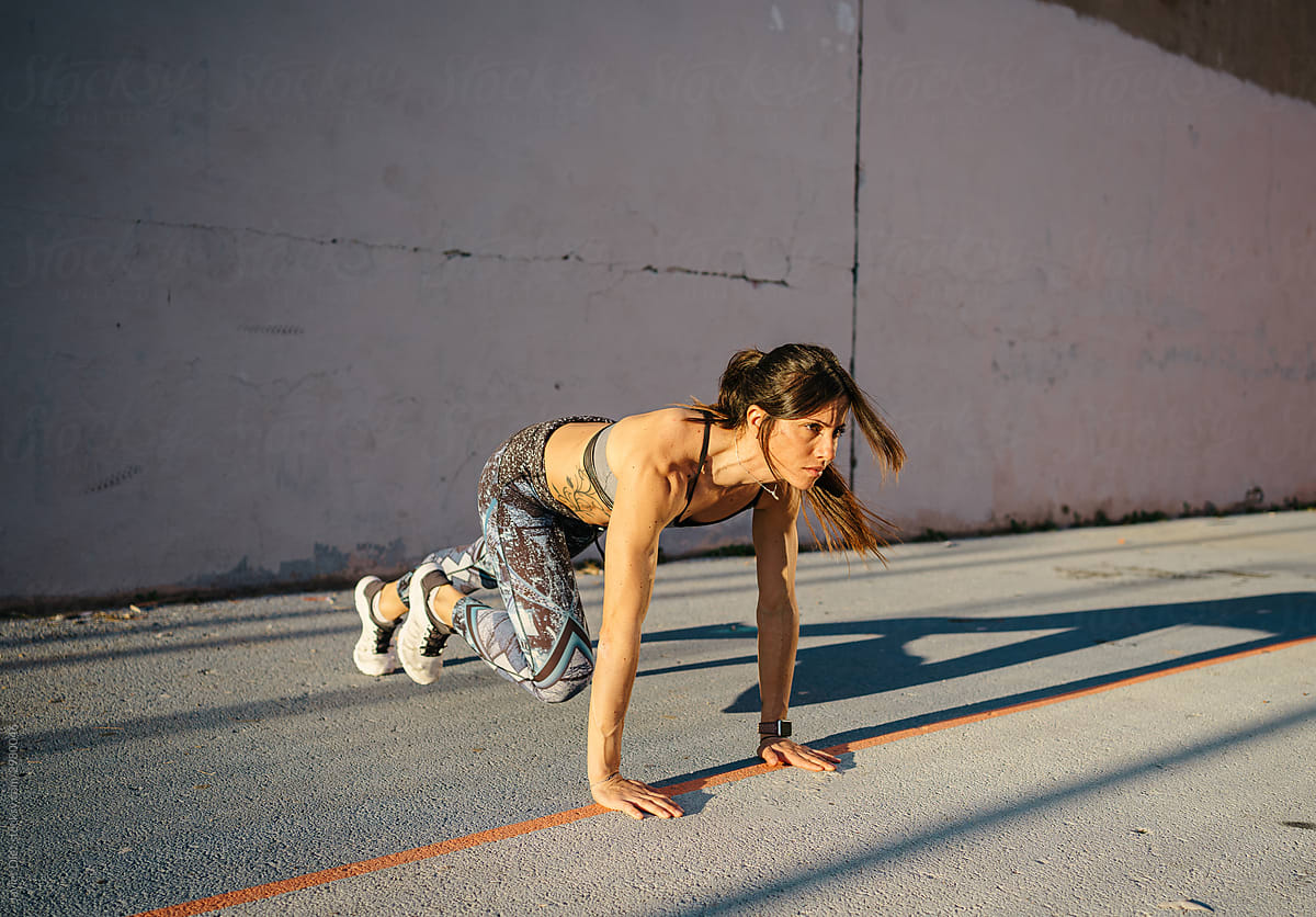 Determined sportswoman exercising on street