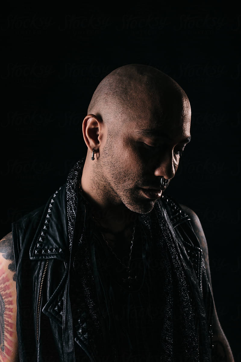 Rough tattooed man portrait over black background
