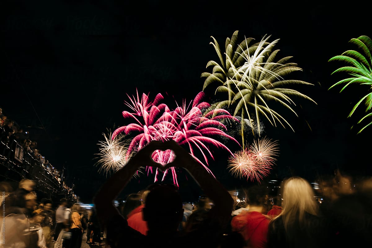 Man hands\' silhouette shaping a heart in front of fireworks