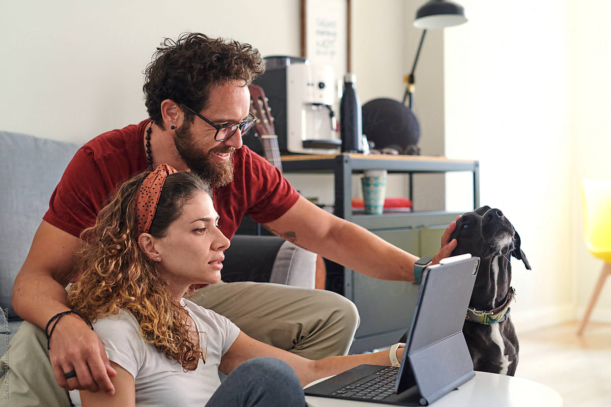 Young couple with dog working with laptop at home
