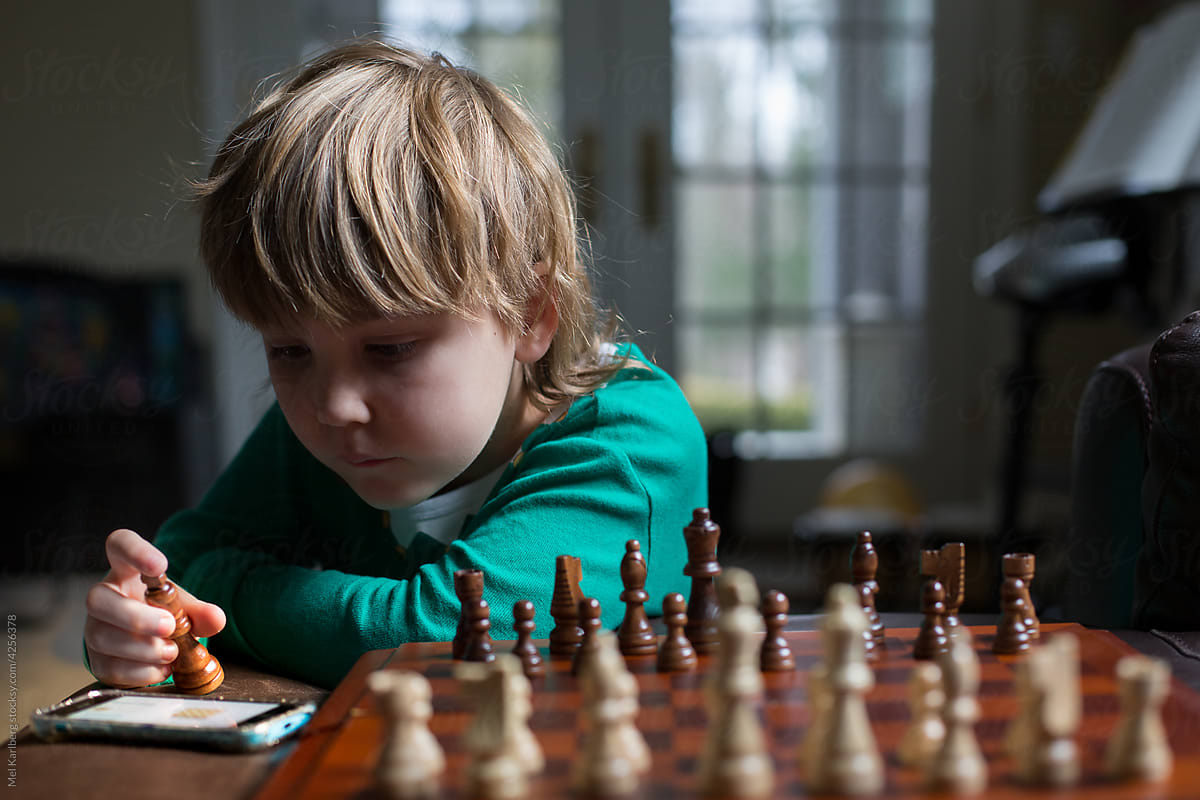 Boy\'s playing chess while wearing elf pajamas
