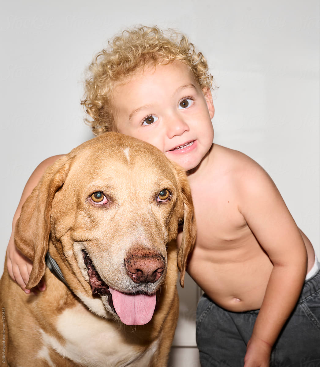 animal friendly: Little boy  hugging his dog pet