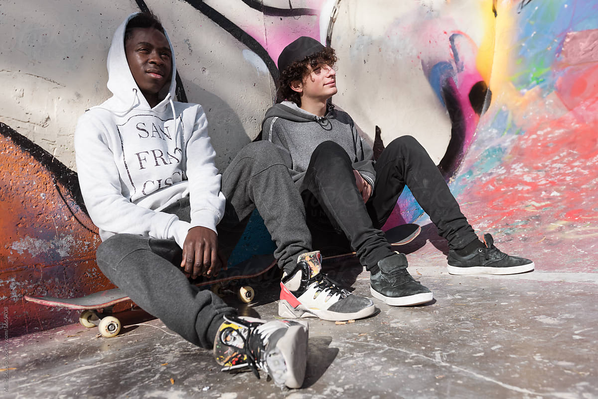 Casual skateboarders at graffiti wall
