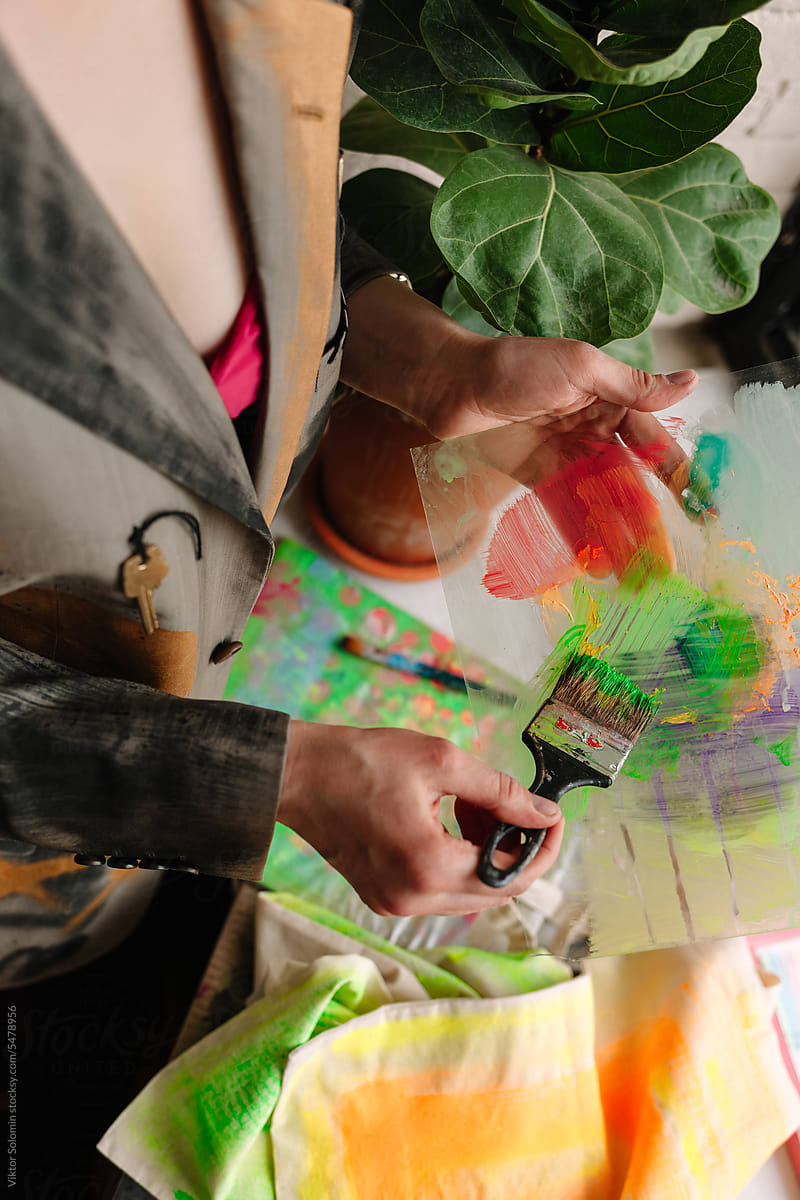 Crop woman fashion designer choosing paint on color palette