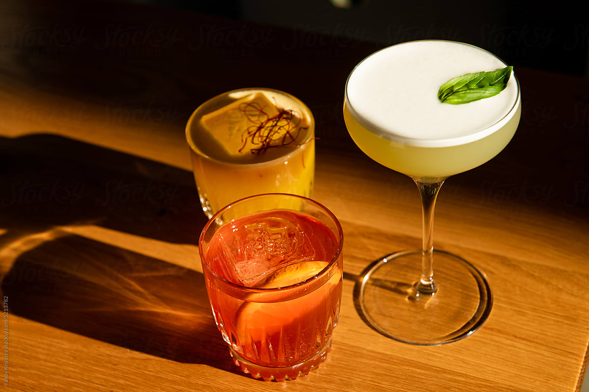 set of three fancy cocktails on the wooden table