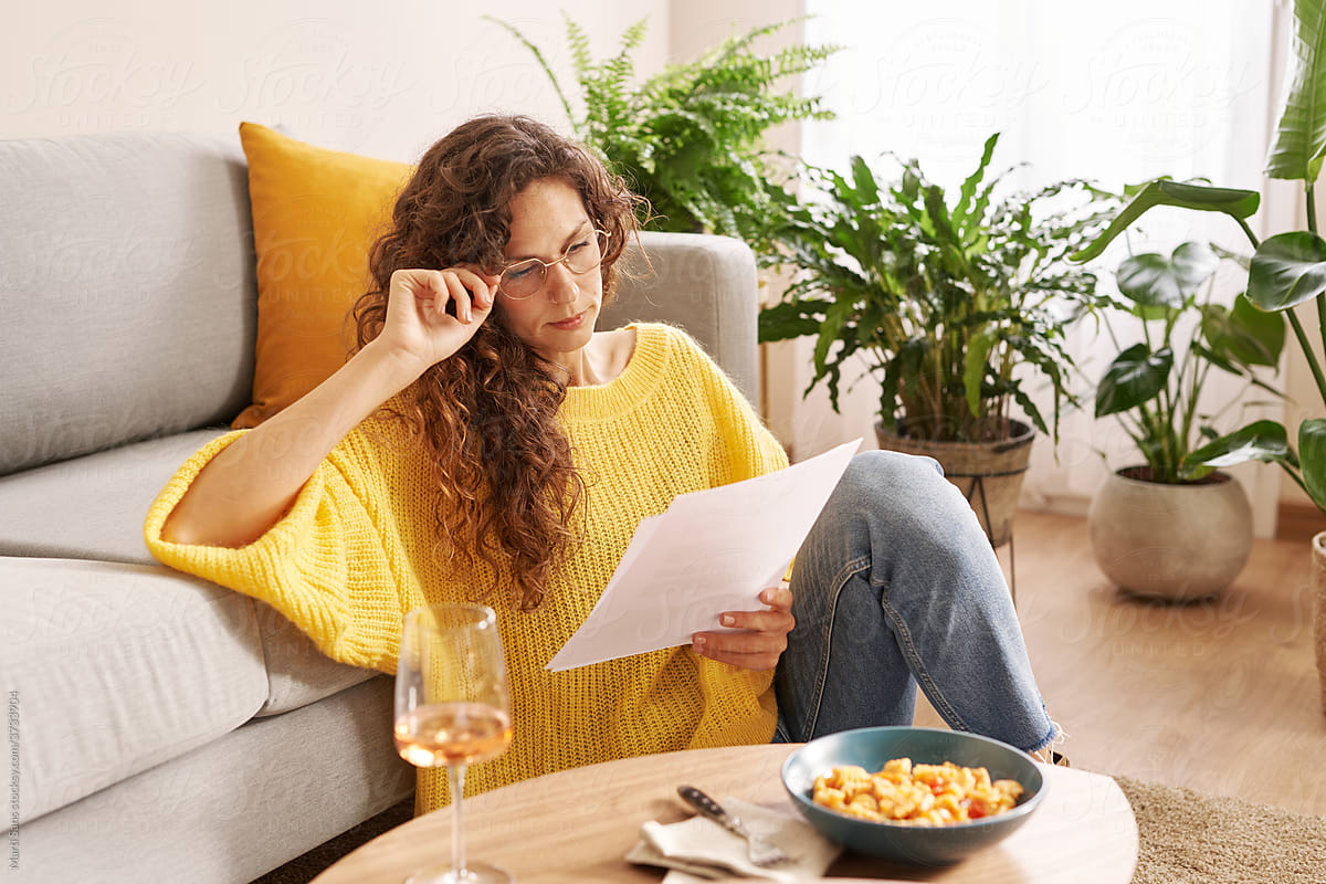 Focused woman reading documents during work at home