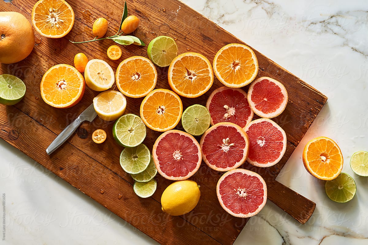 Oranges Lemons And Limes Citrus On Wooden Cutting Board By Trent Lanz Colorful Fruit Stocksy United