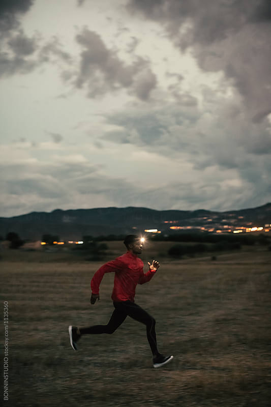 African american man running on a field at evening.
