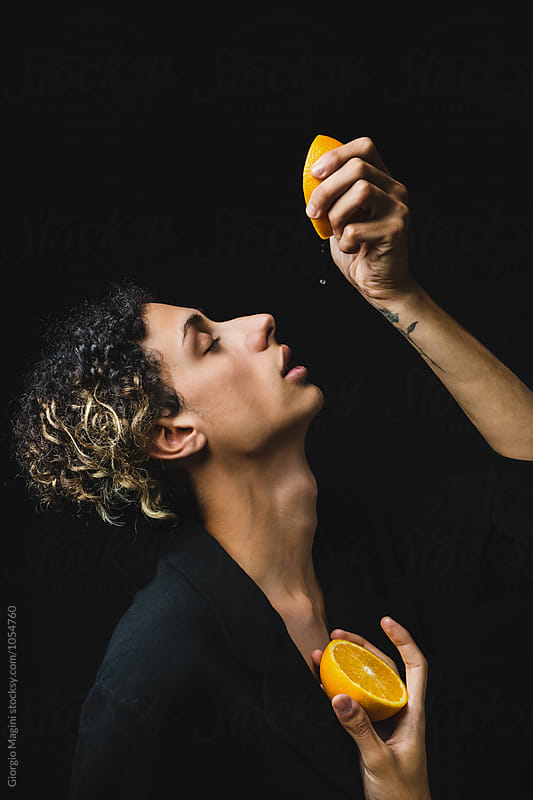 Feminine Boy Squeezing an Orange, Studio Portrait