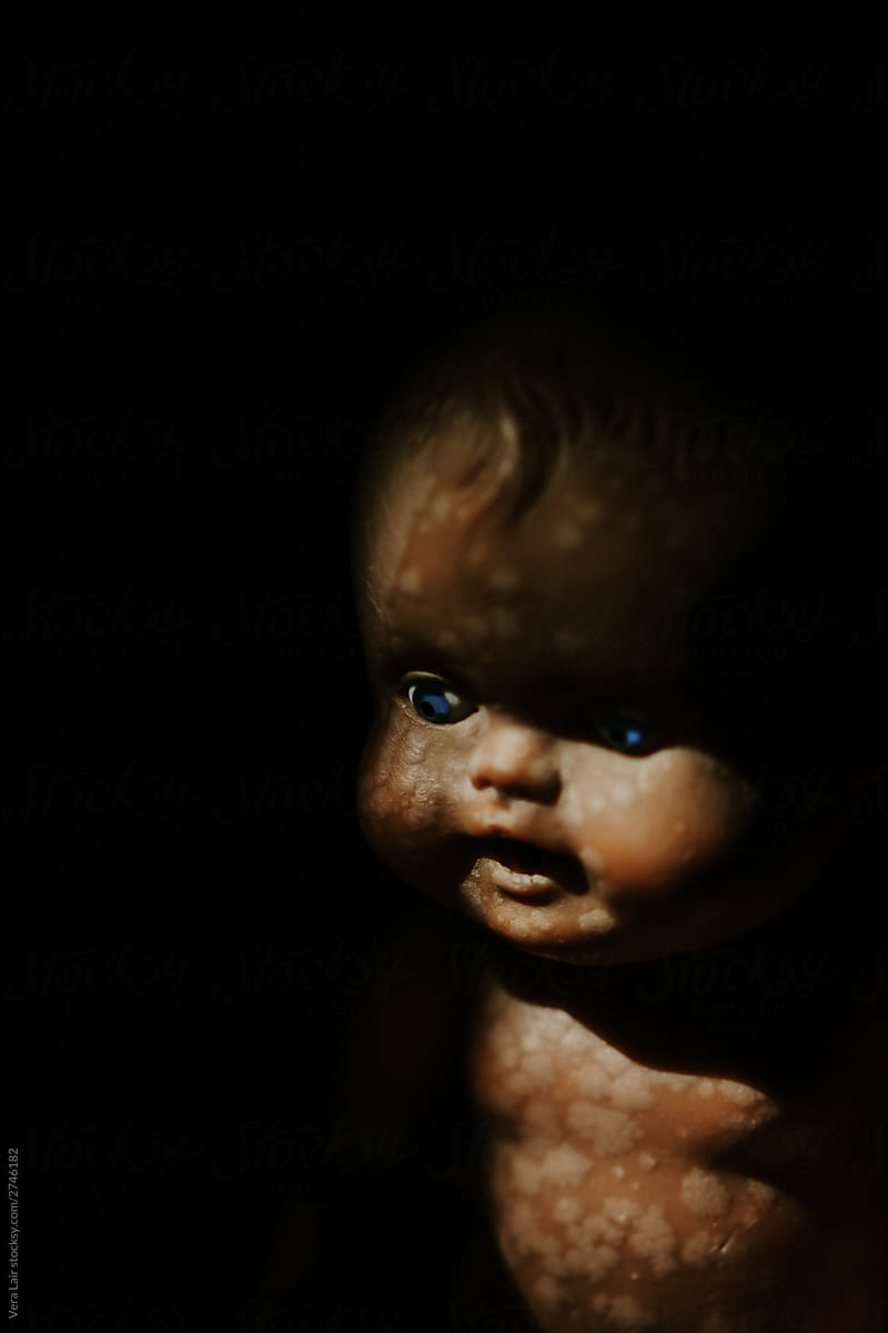 close up of a vintage baby doll,\
in the shadow