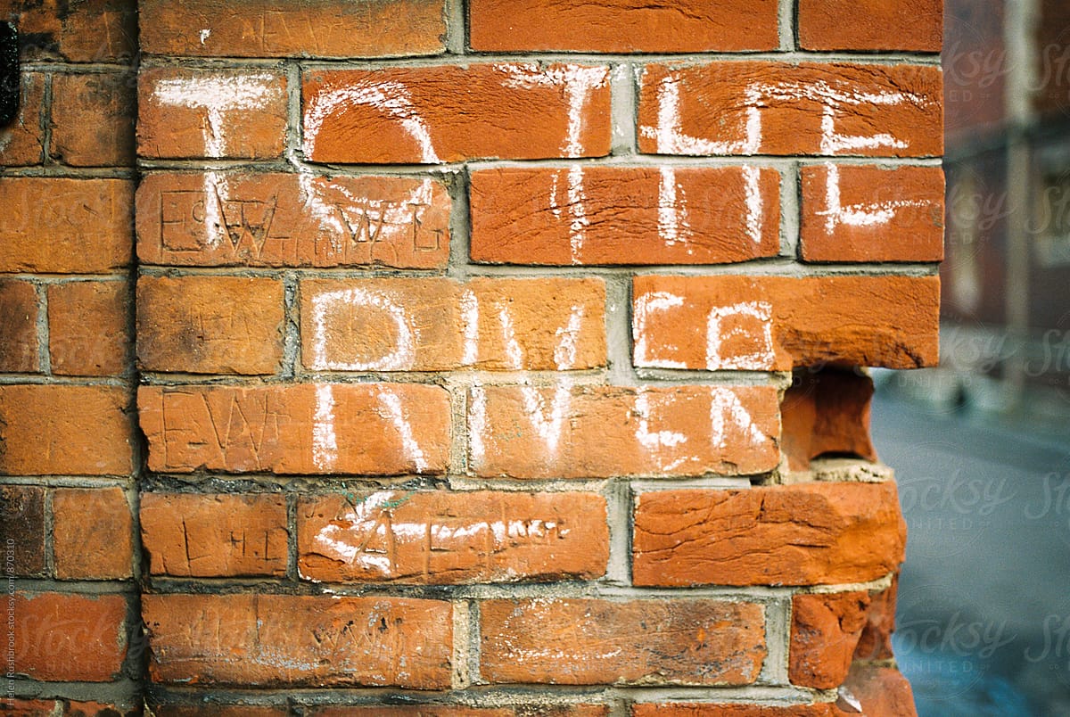 A chalked sign on a brick wall reading To The River