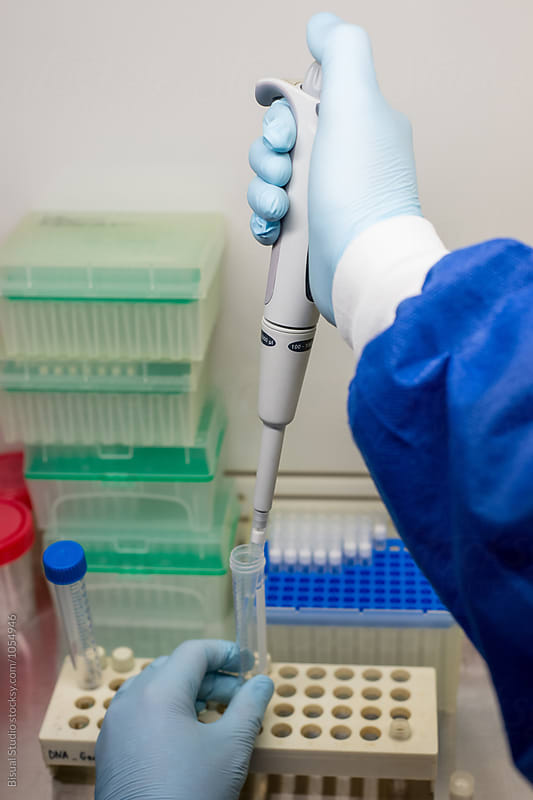 Female scientist using a pipette in a DNA laboratory