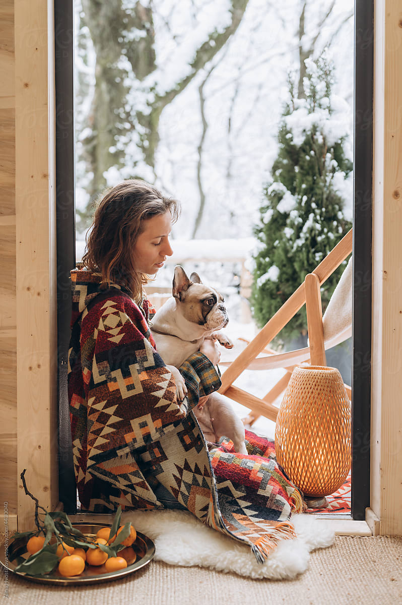 Smiling woman with dog sitting in doorway