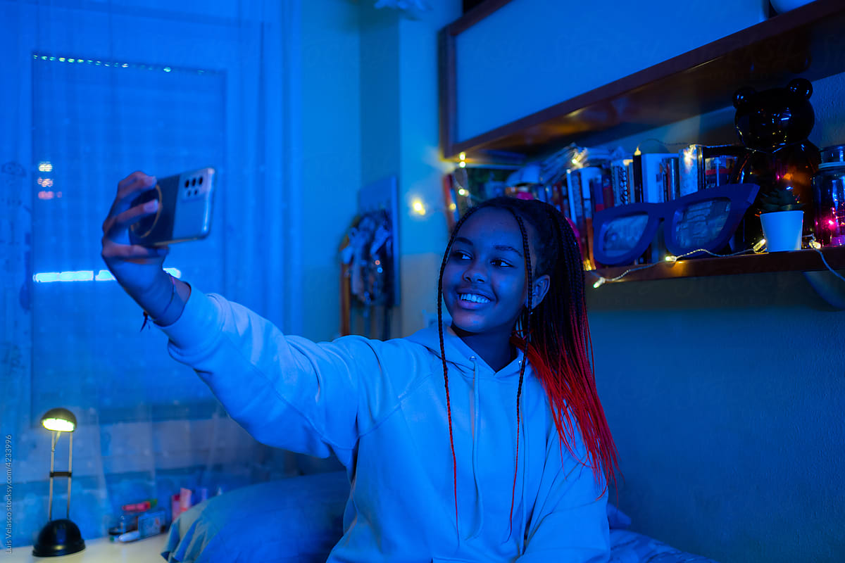 Teen Black Girl Smiling Taking A Selfie In Her Bedroom.