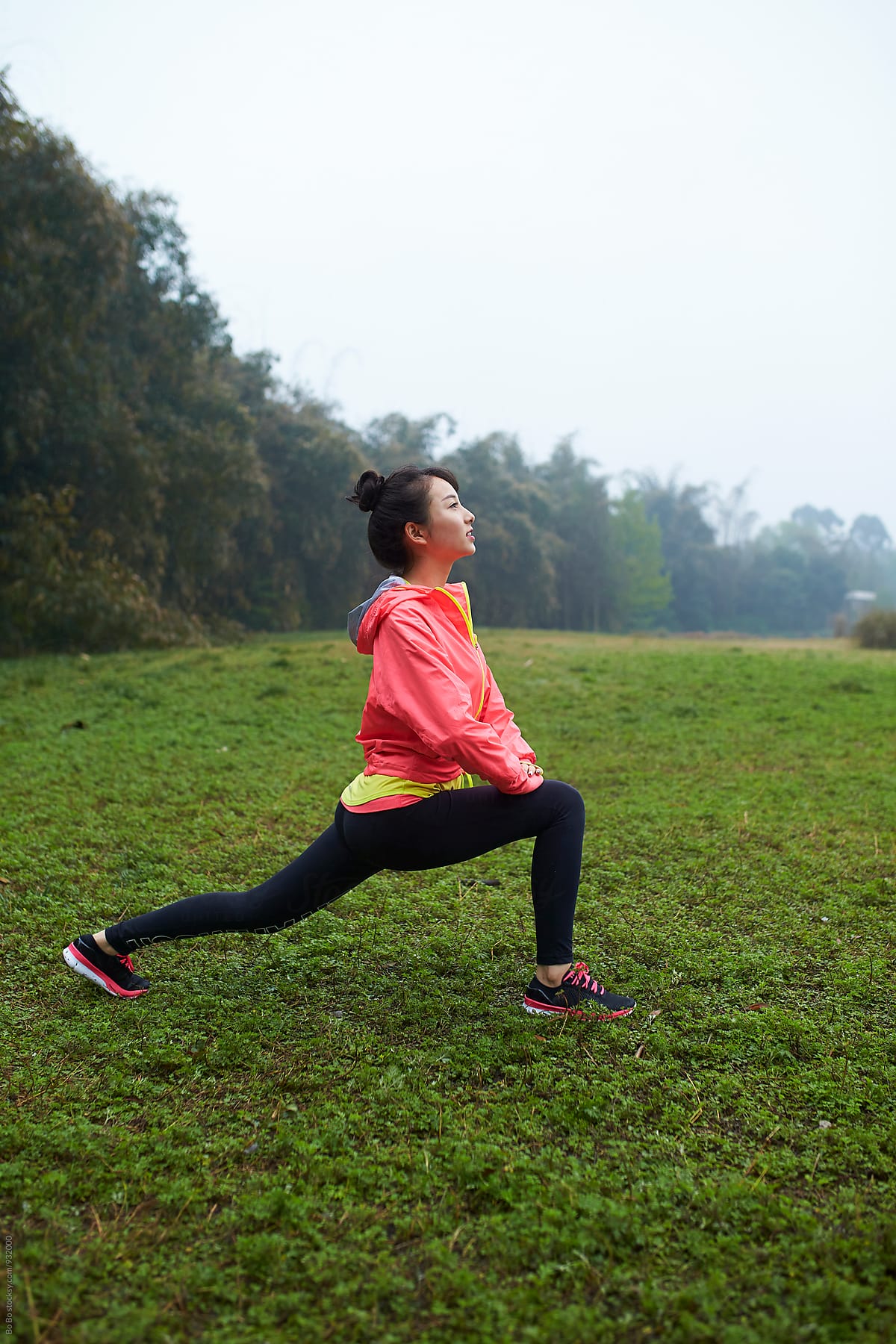 young asian woman doing warm up outdoor before running