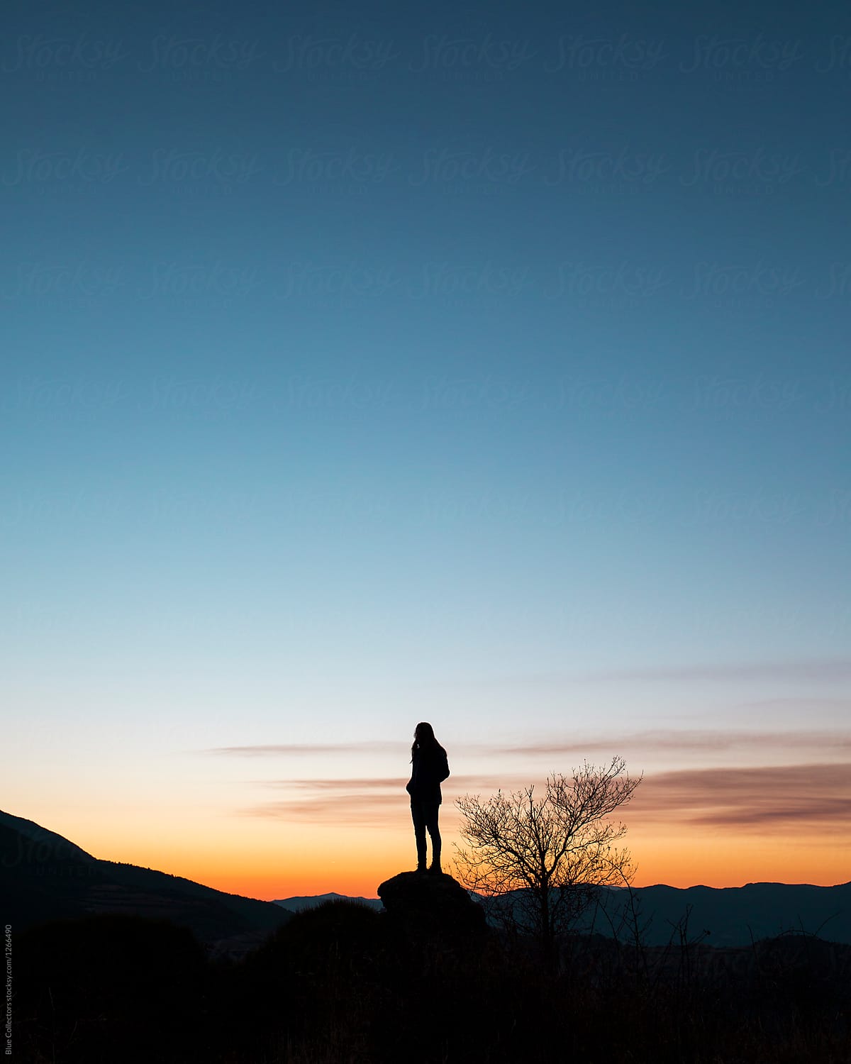 Silhouette of woman watching the sunset in the mountains