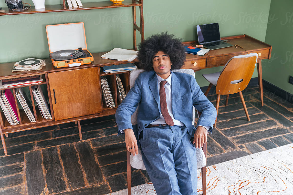 Young businessman with afro  listening music
