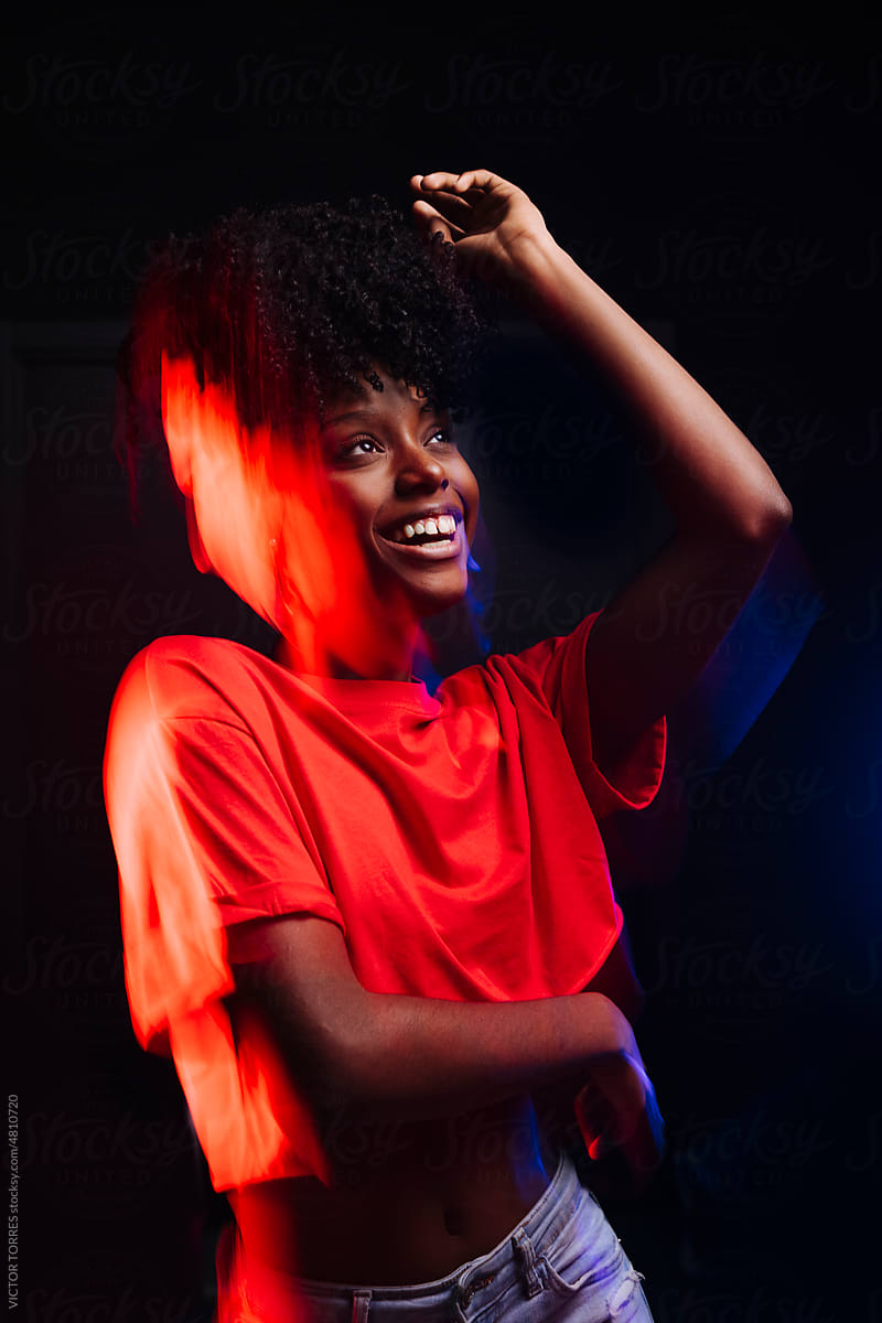 Cheerful black woman with raised arms