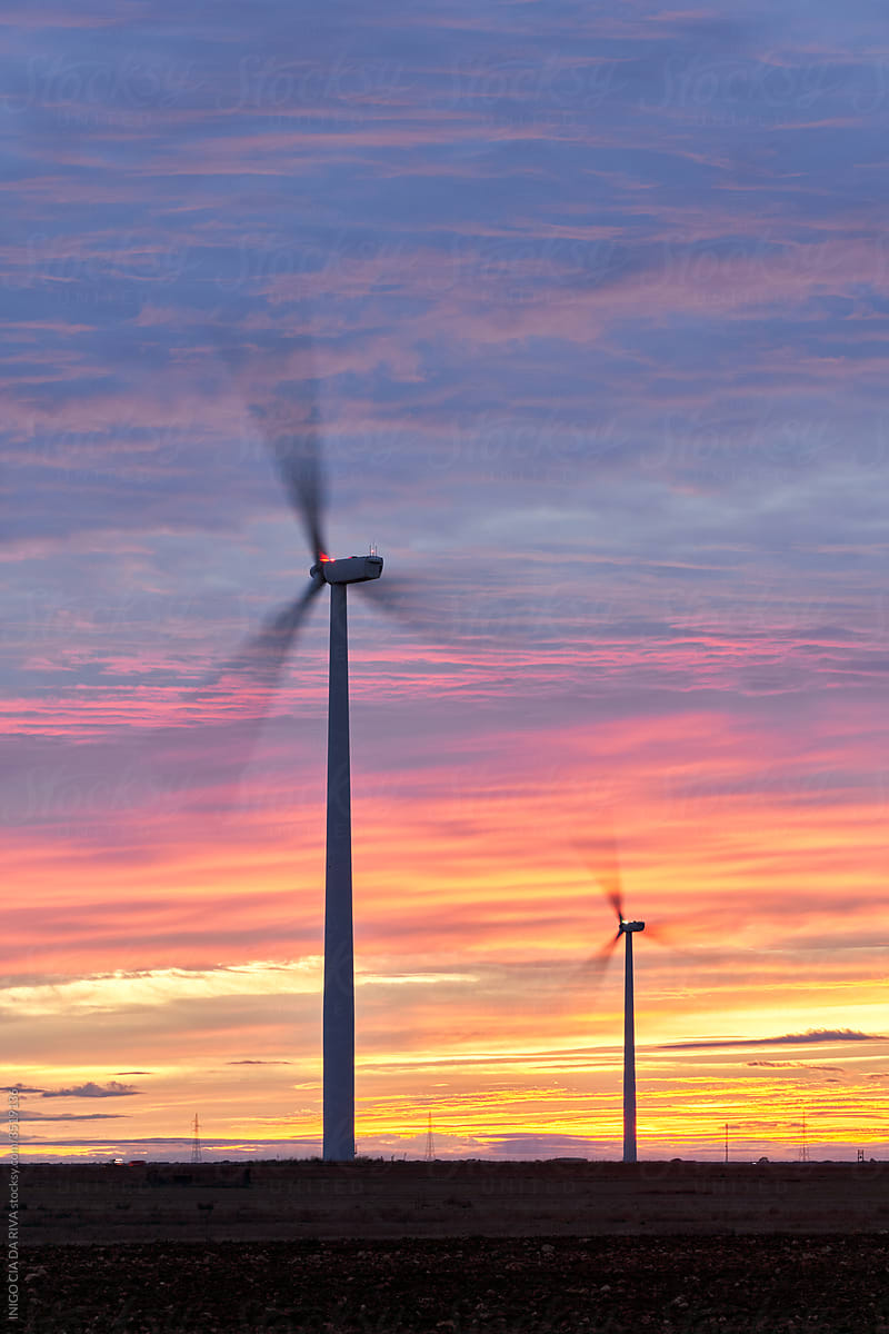Windmills under cloudy sunset sky
