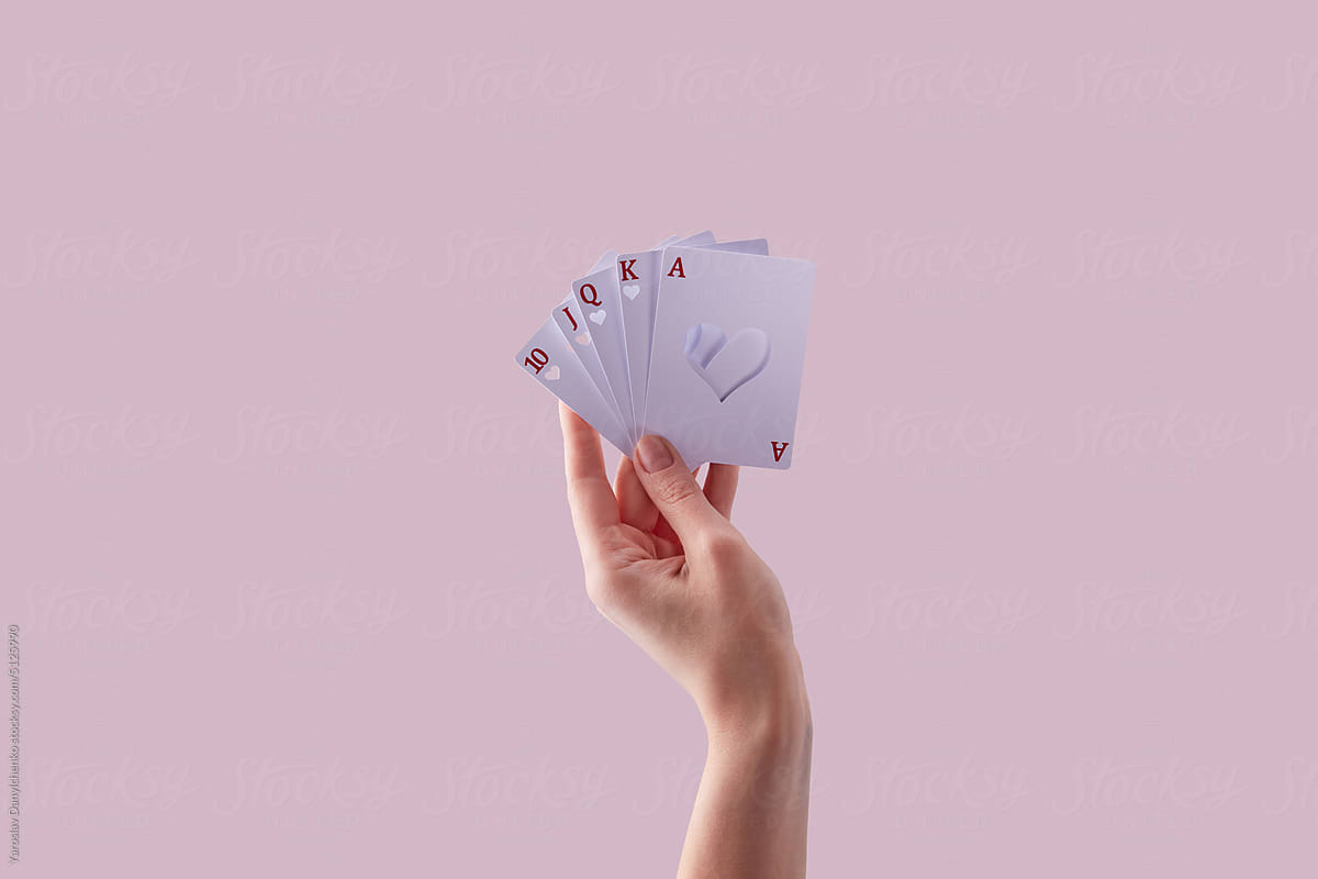 Cards with cut heart hollow in woman\'s hand.
