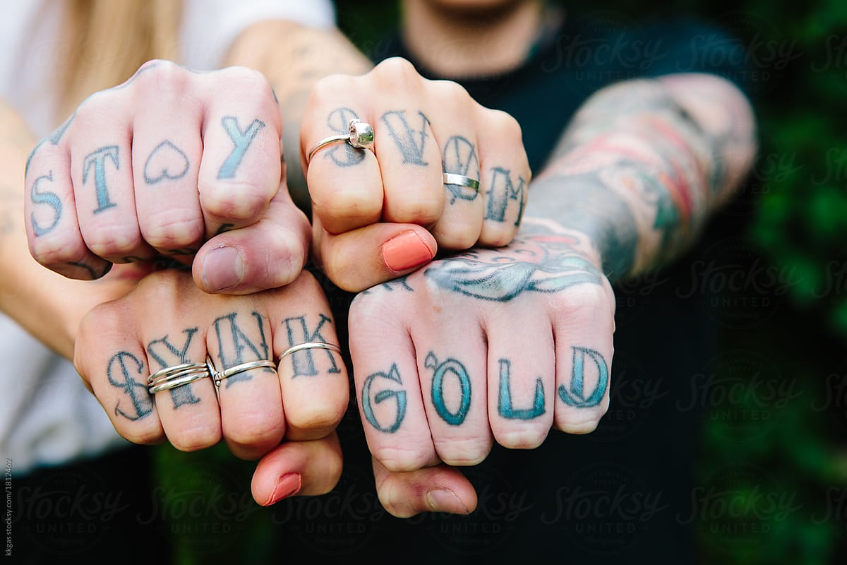 Two Pairs Of Tattooed Hands Together Showing Tattooed Knuckles And Rings