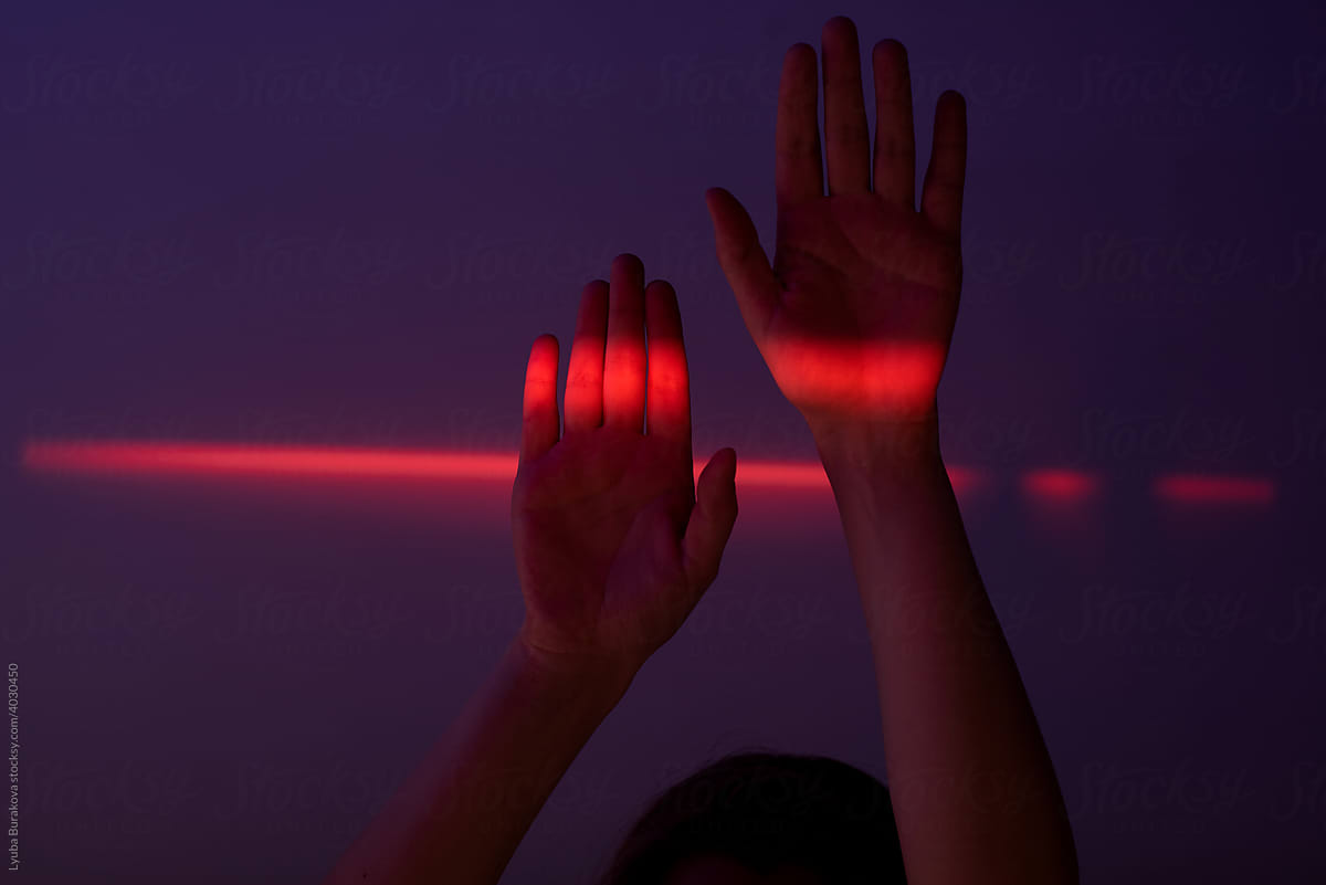 Neon red light on hands