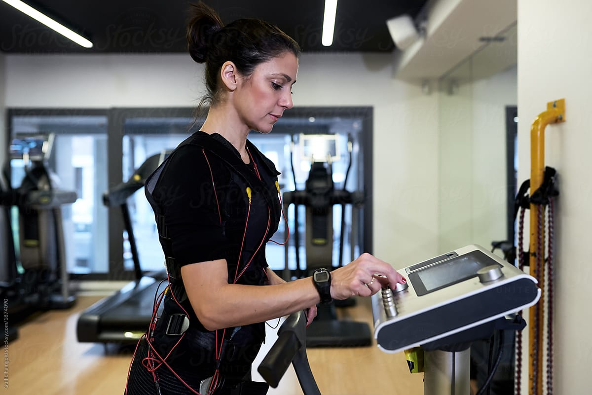 Sportswoman in bodytech vest on treadmill.