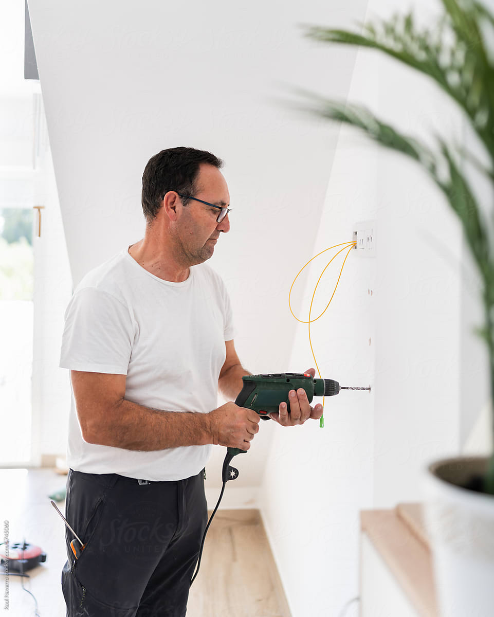 portrait of senior man using electric drill