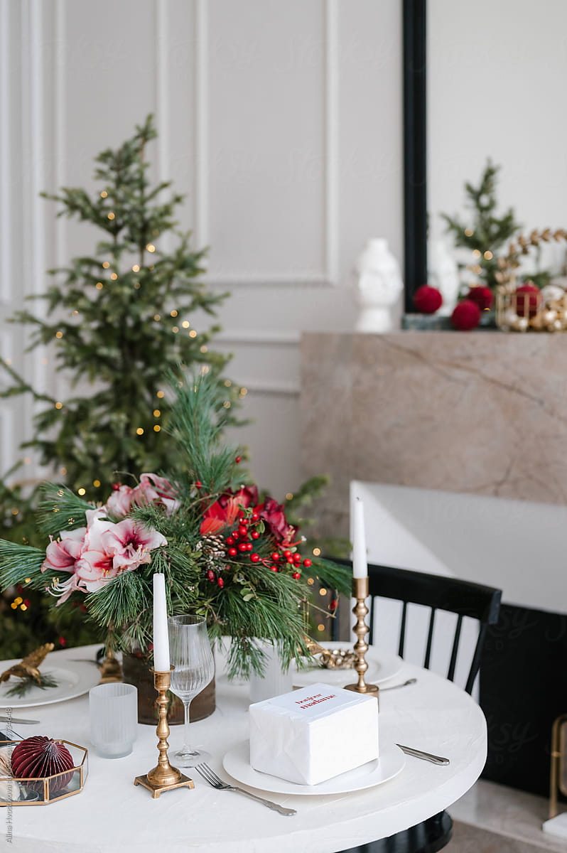 Elegant table setting with classic dishware and spruce decor in cozy room during Christmas dinner