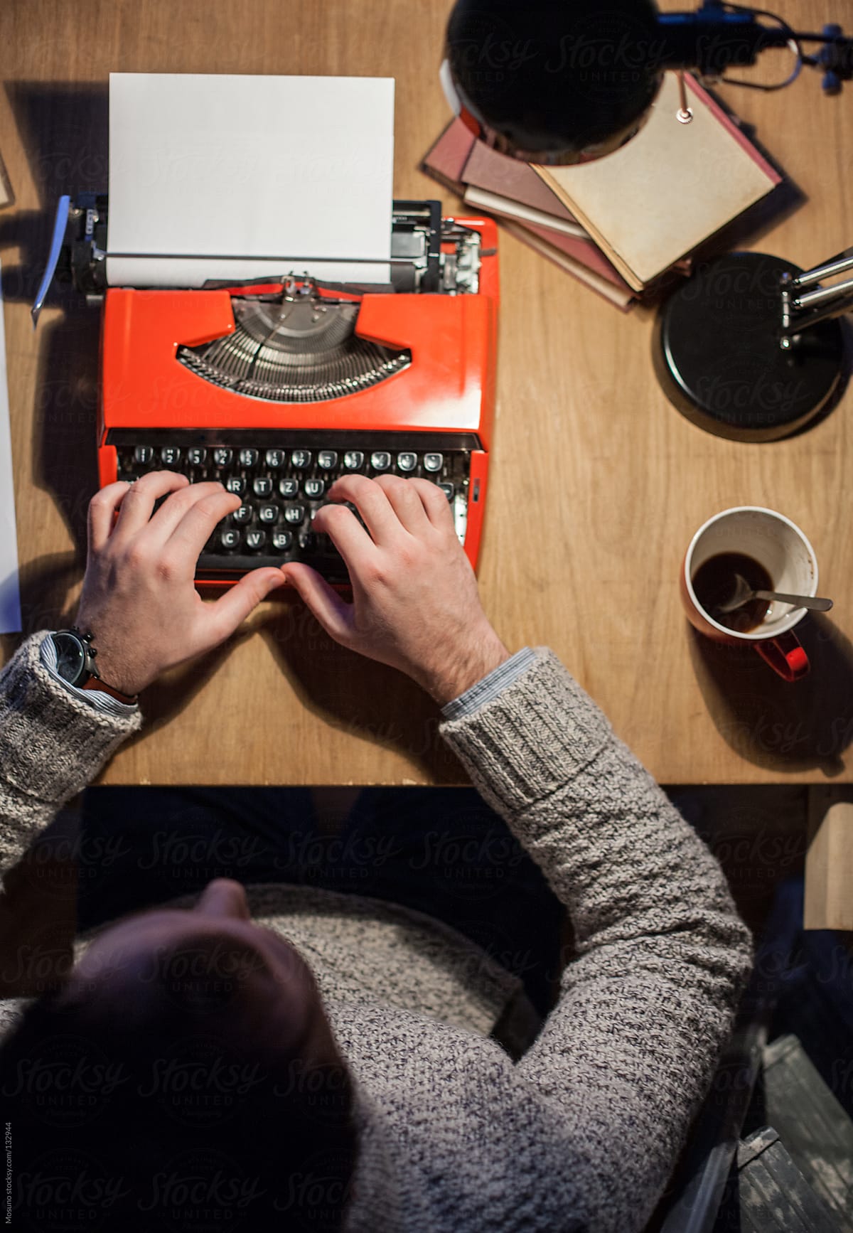 Man working on a typewriter at night.