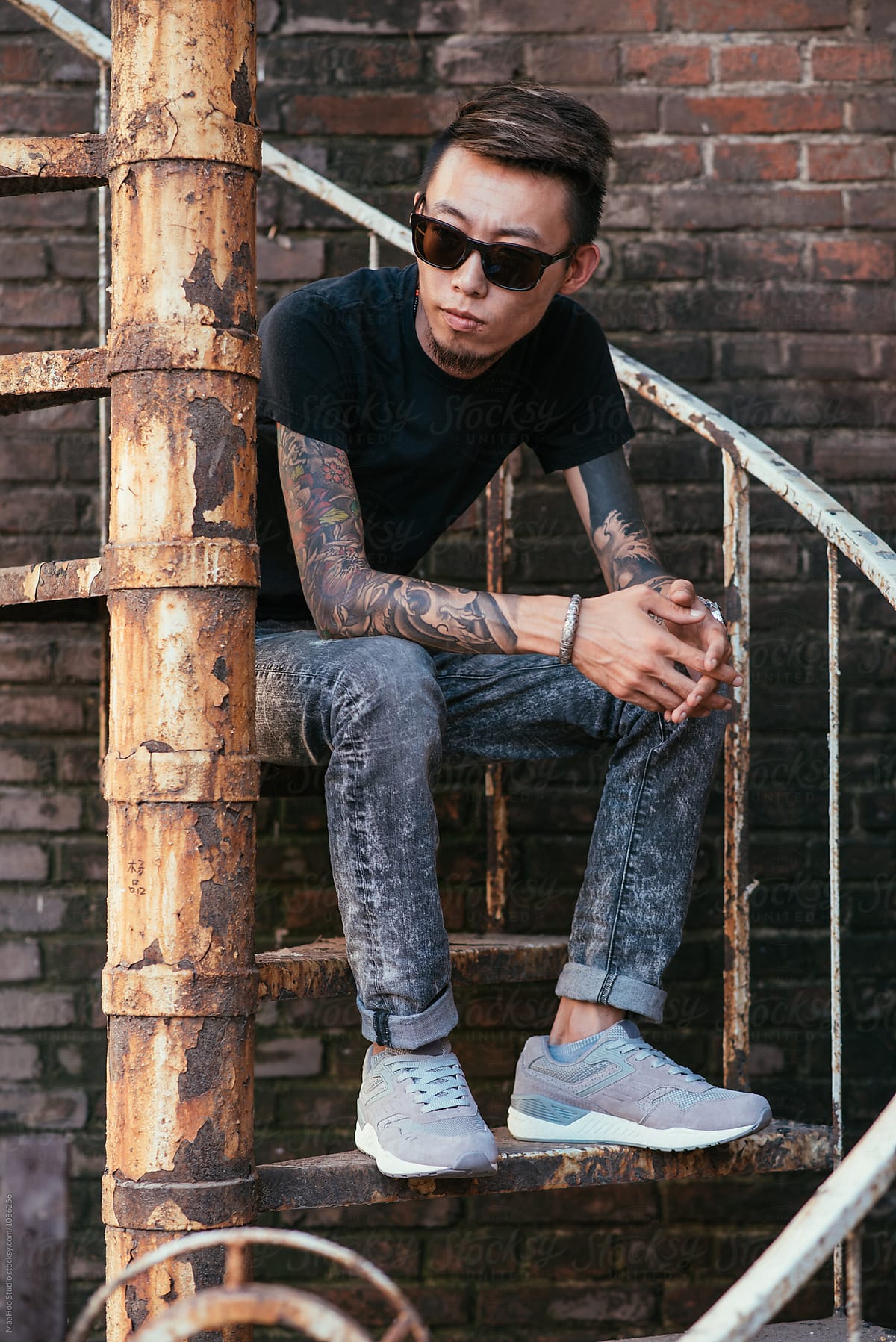 Portrait of man with tattoo sitting on stairs