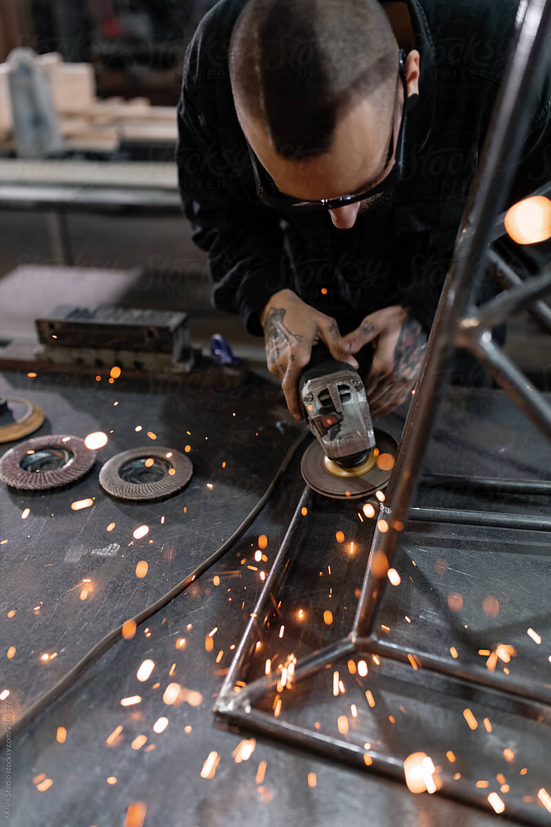 Man grinding metal parts with sparks flying