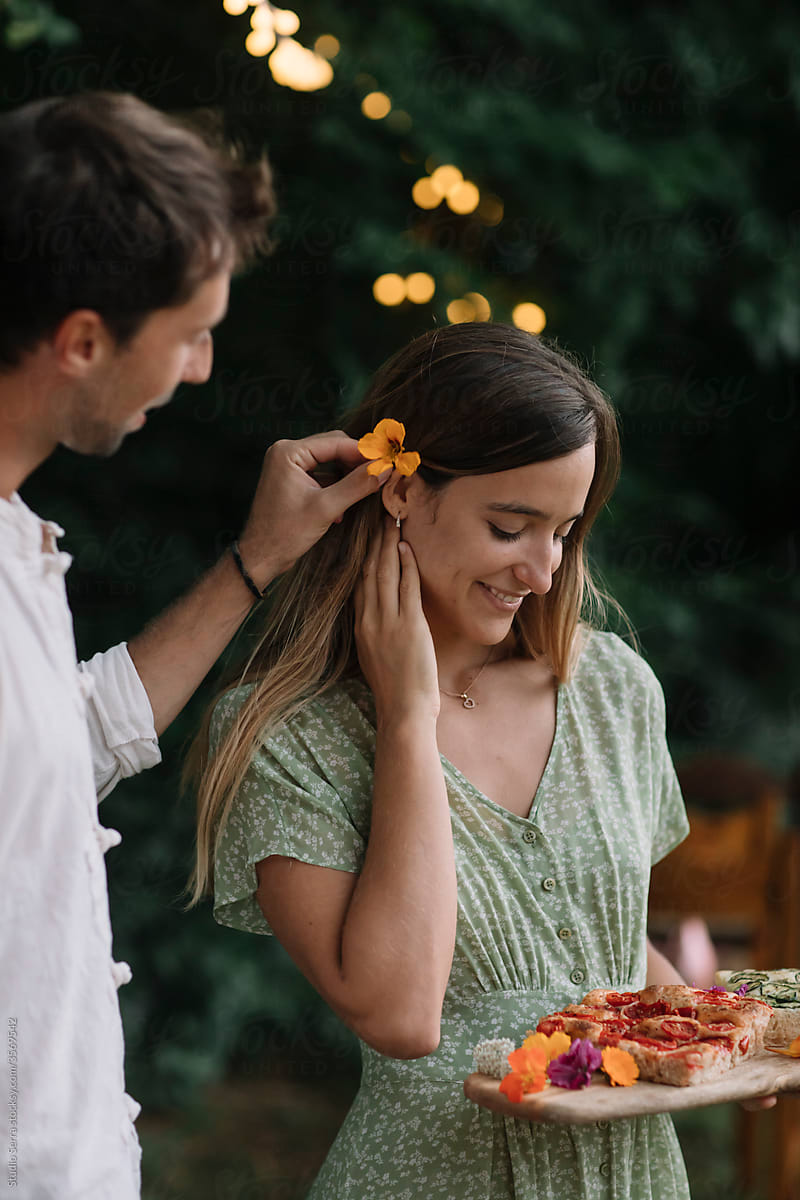 Young Man Putting A Flower In A Girl's Hair