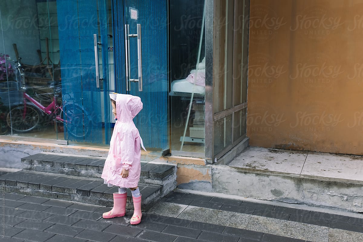 Little girl wearing raincoat on street
