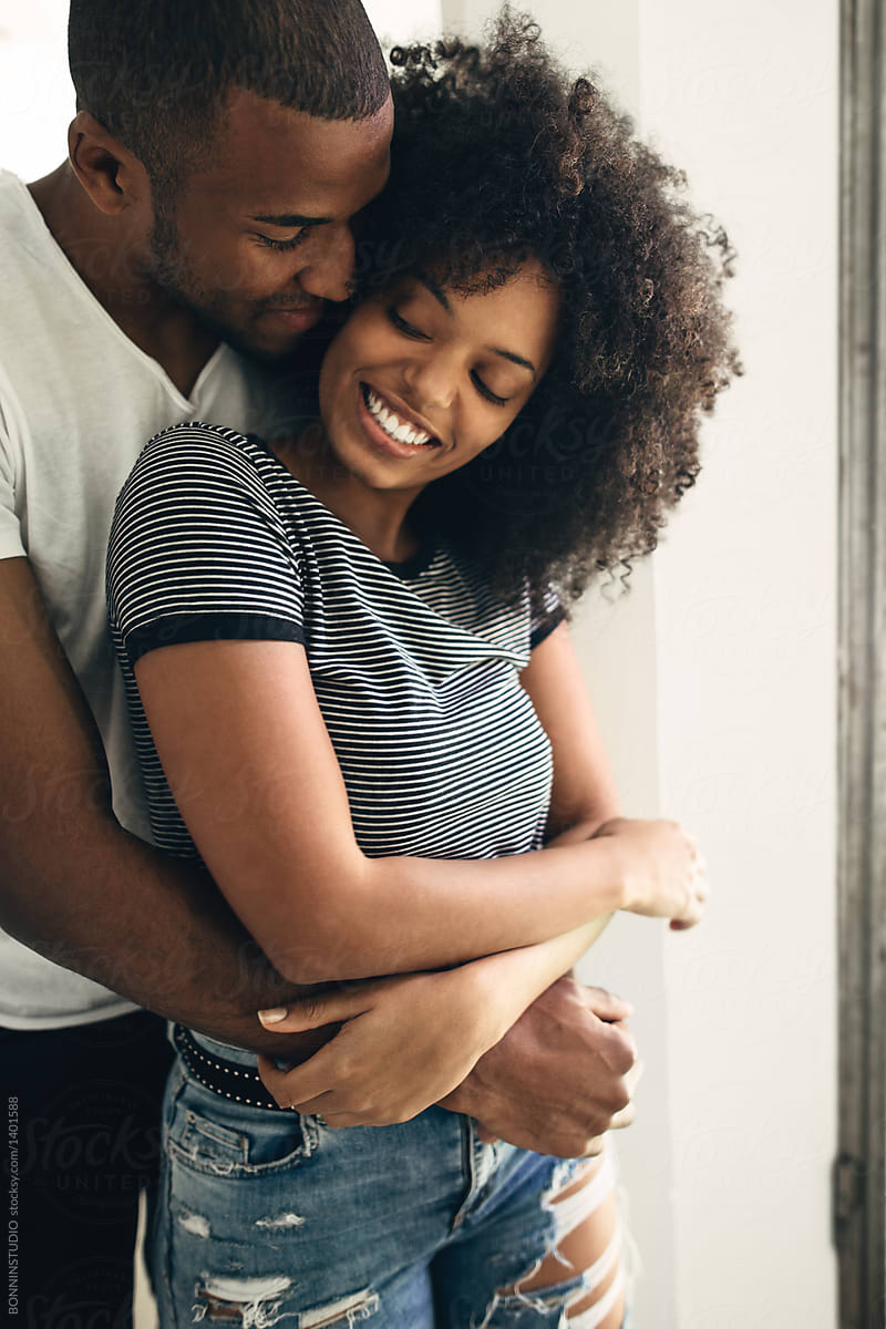 Young black couple embracing at home by BONNINSTUDIO - Stocksy United