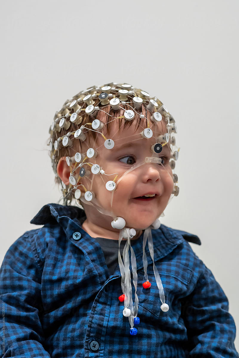 Funny toddler in EEG cap in a lab