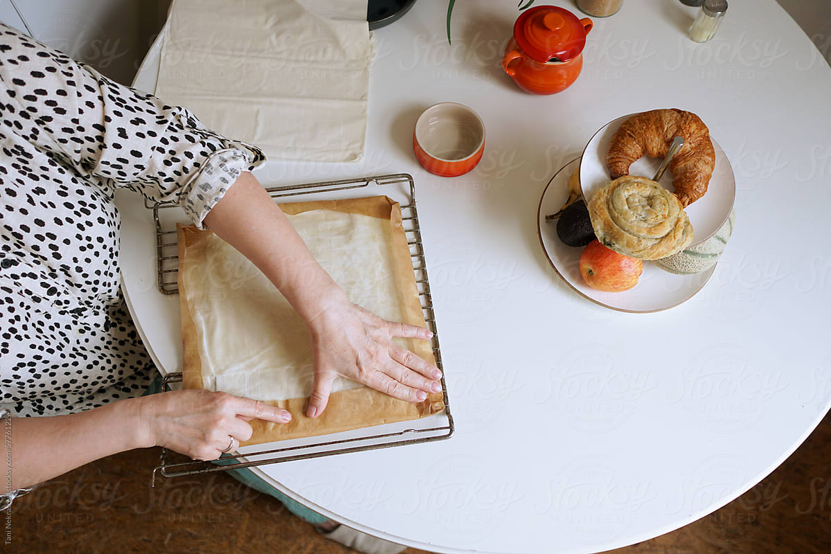 A woman\'s hands make a pie in a cozy and bright kitchen at home
