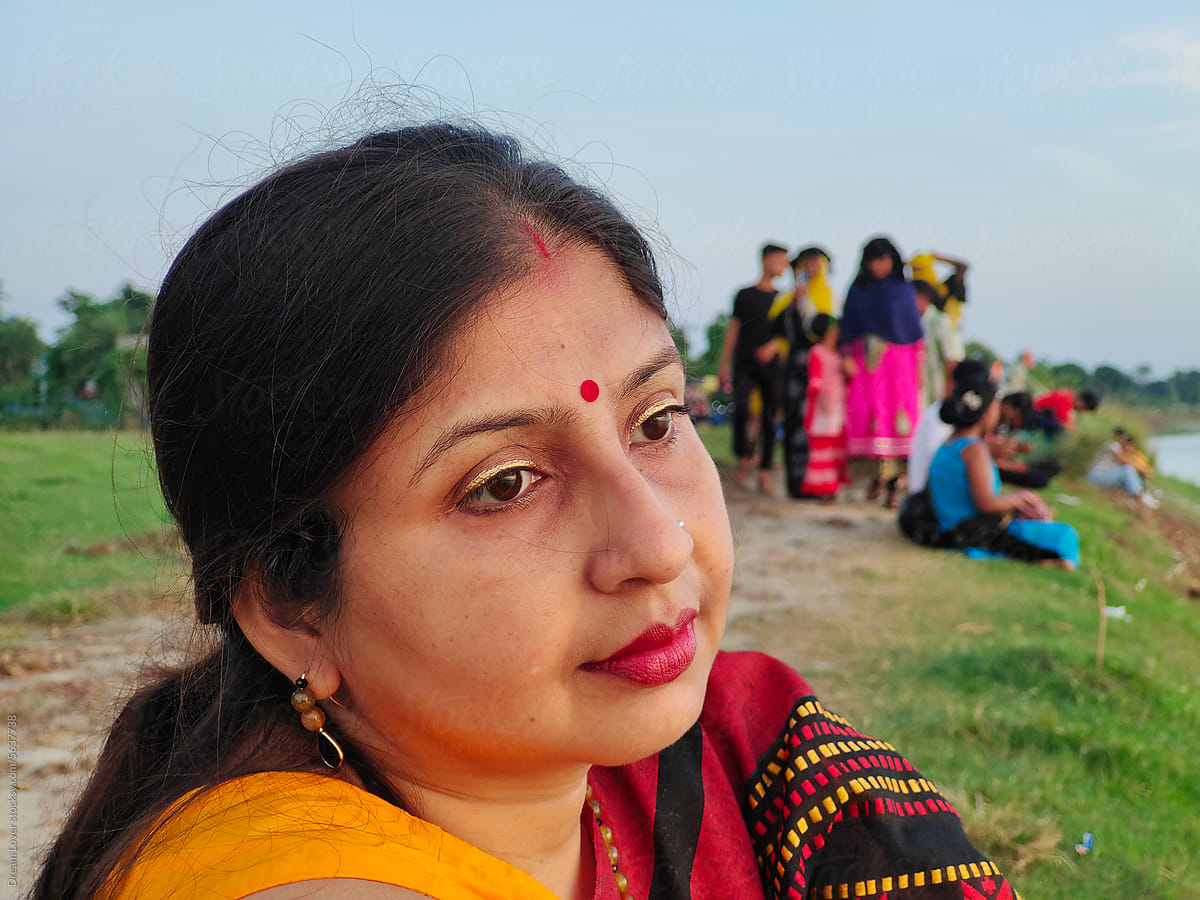 Portrait of a beautiful Indian woman sitting by the side of a river