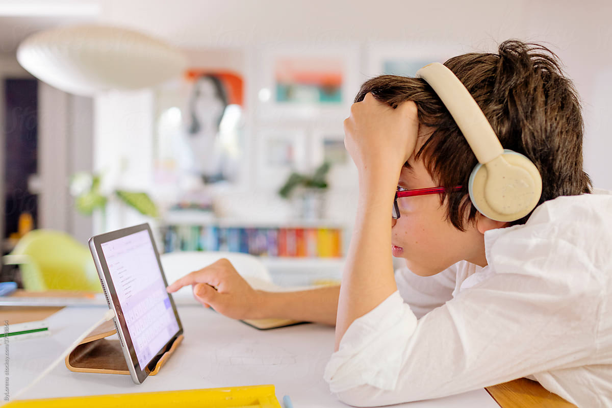 Side view teen Boy wearing headphones and tablet