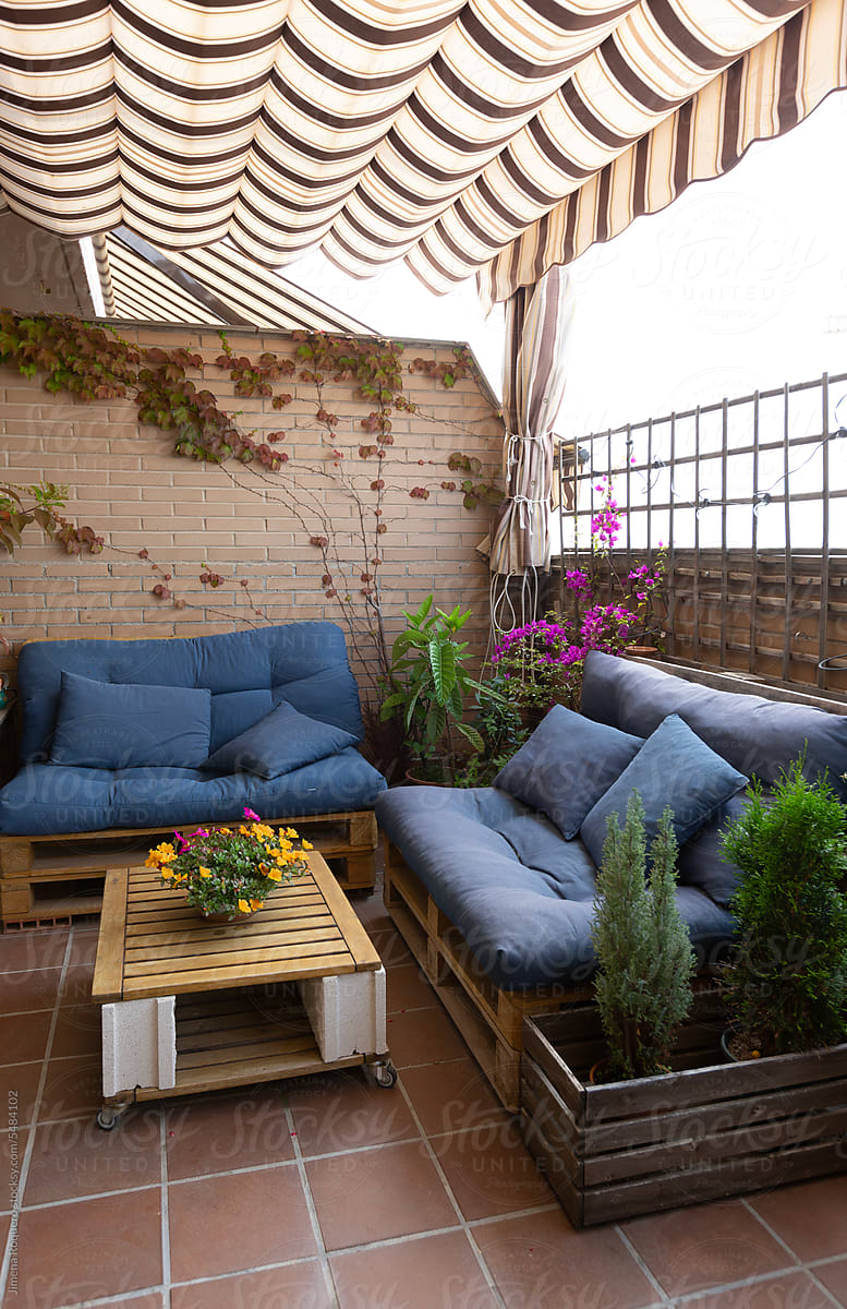 Terrace with diy cozy decor and striped owning and plants