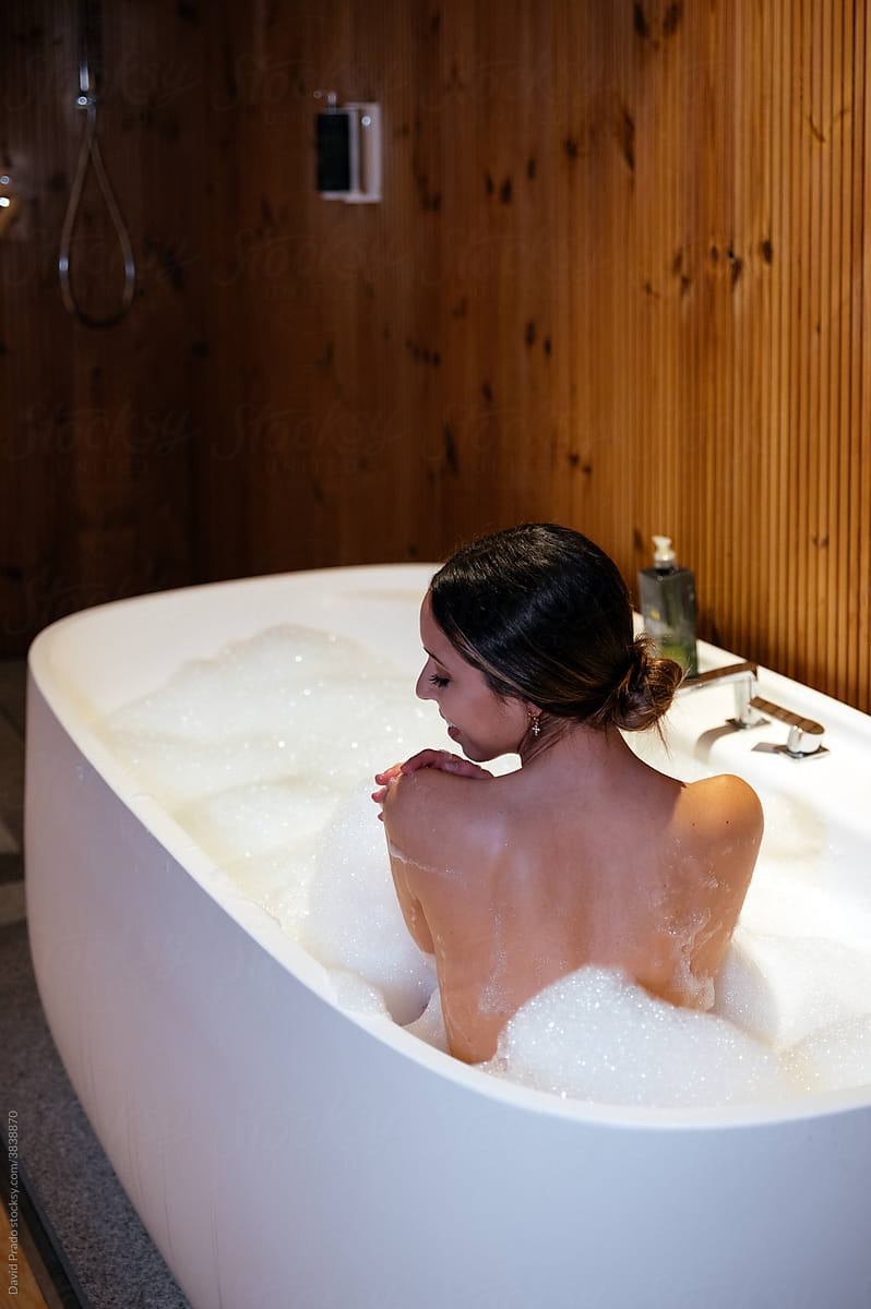 anonymous Woman relaxing in bathtub with foam