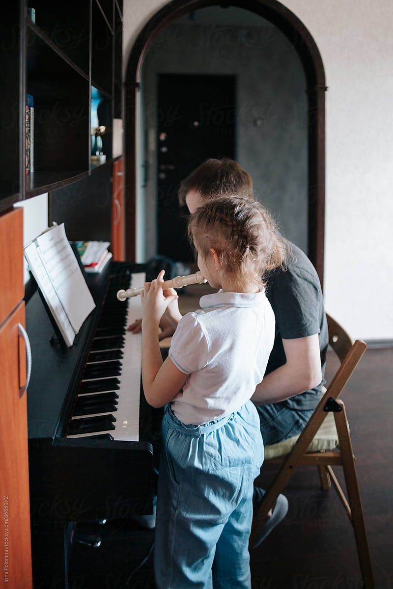 Dad and daughter play music at home.