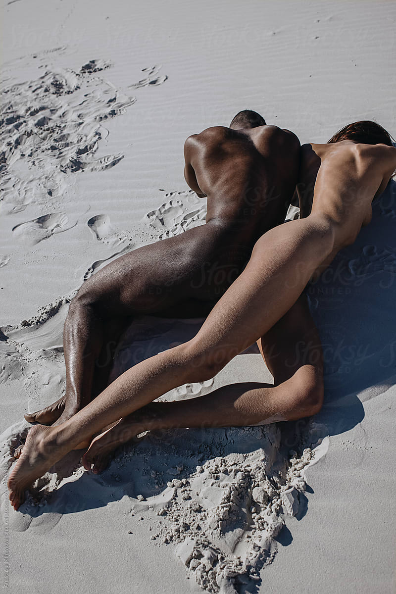 Nude couple lying on the sand