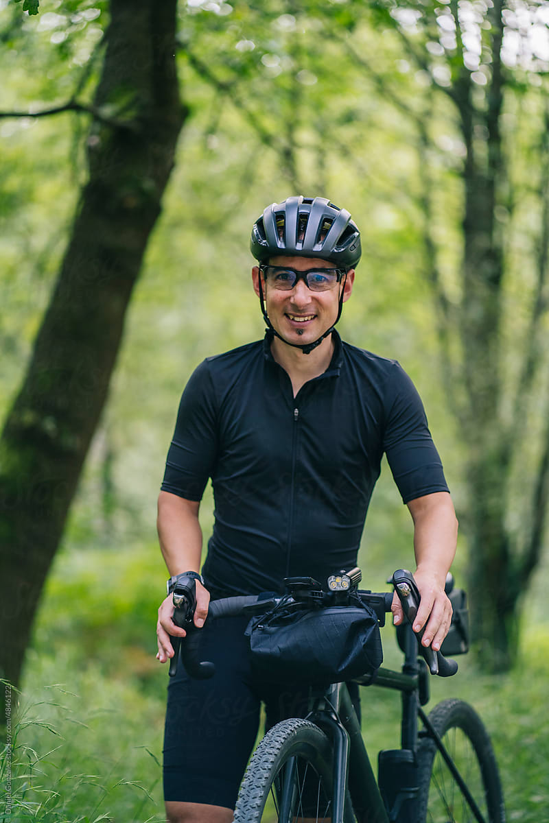 Happy guy smiling near gravel bicycle in woods