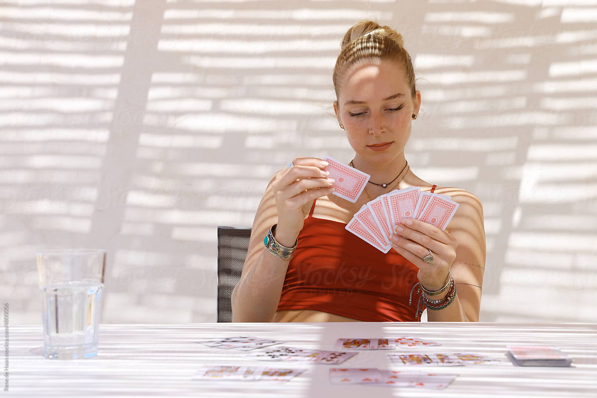 young female holding deck of cards