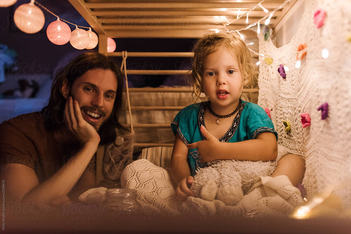 Content father with girl chilling on bed