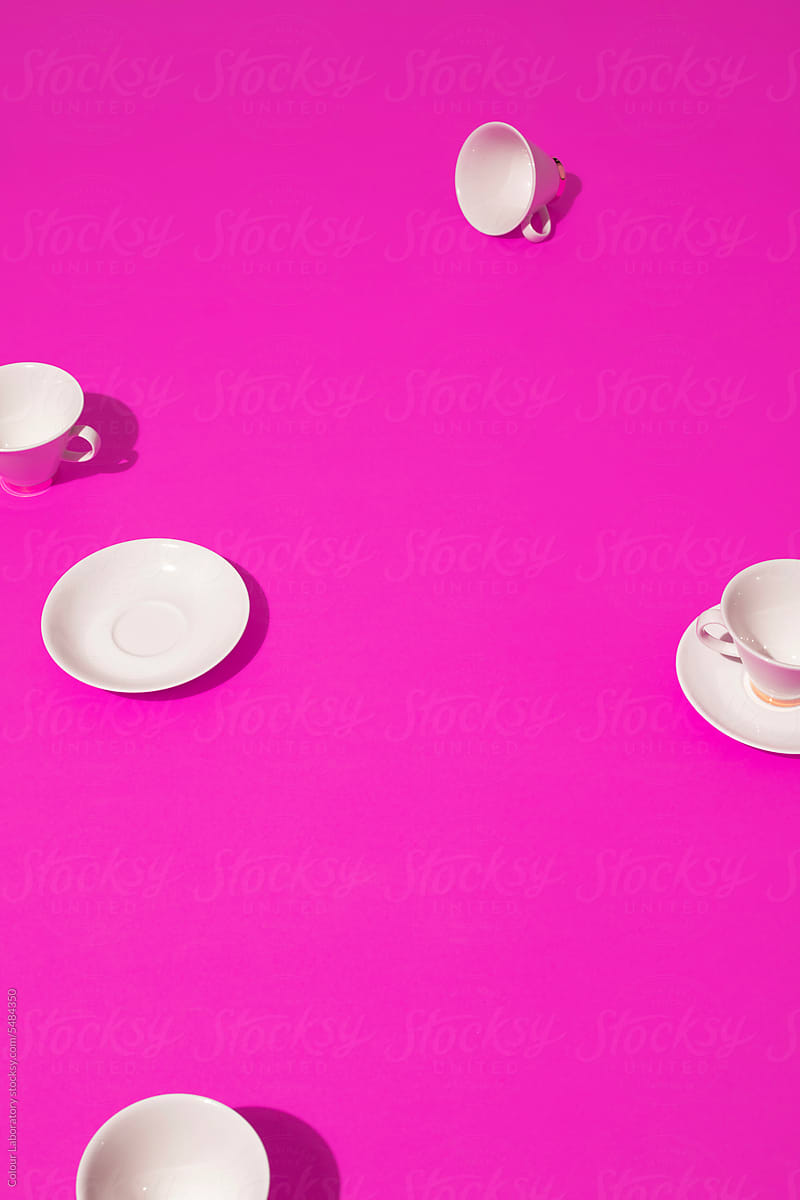 White tea cups and bright pink background