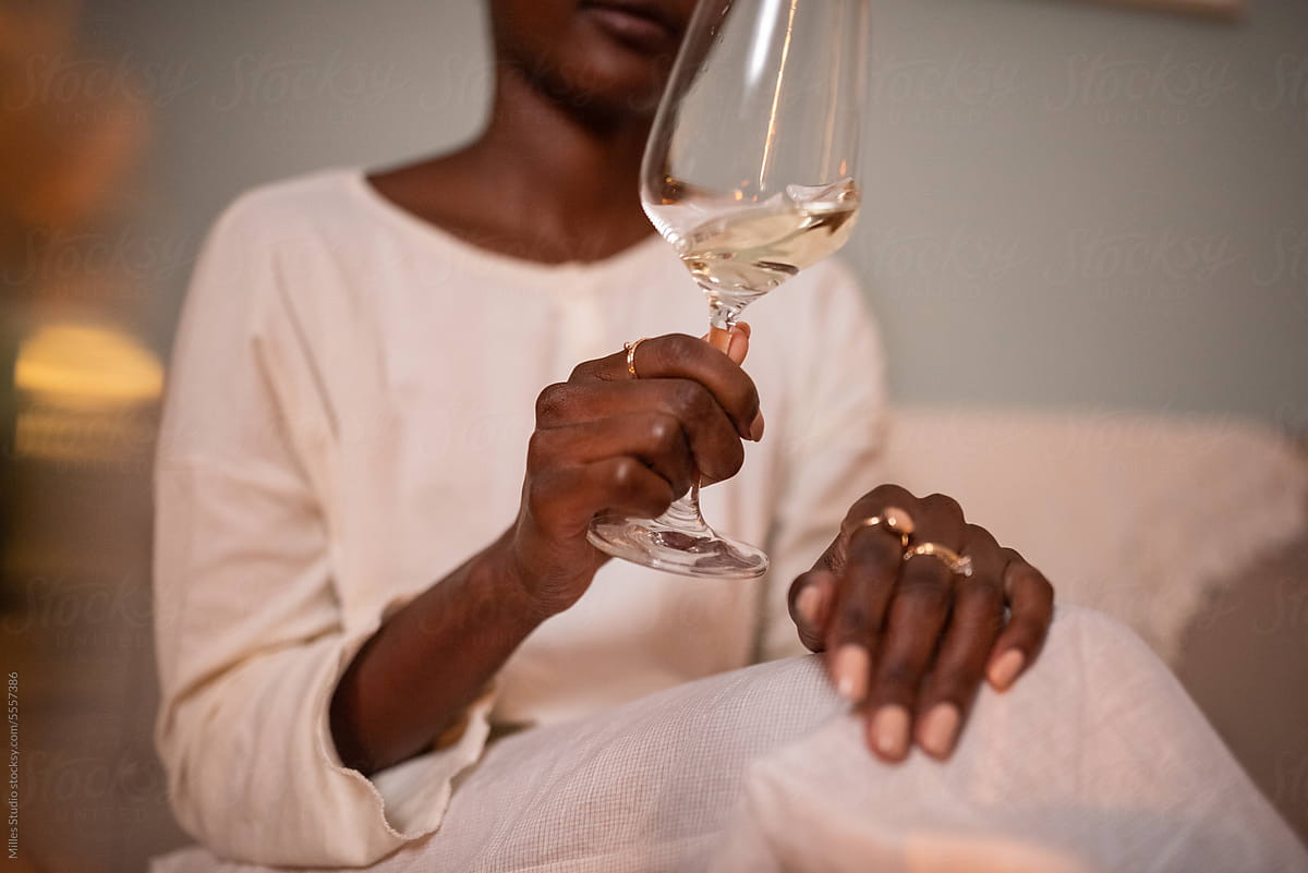 Black woman swirling glass of wine at home