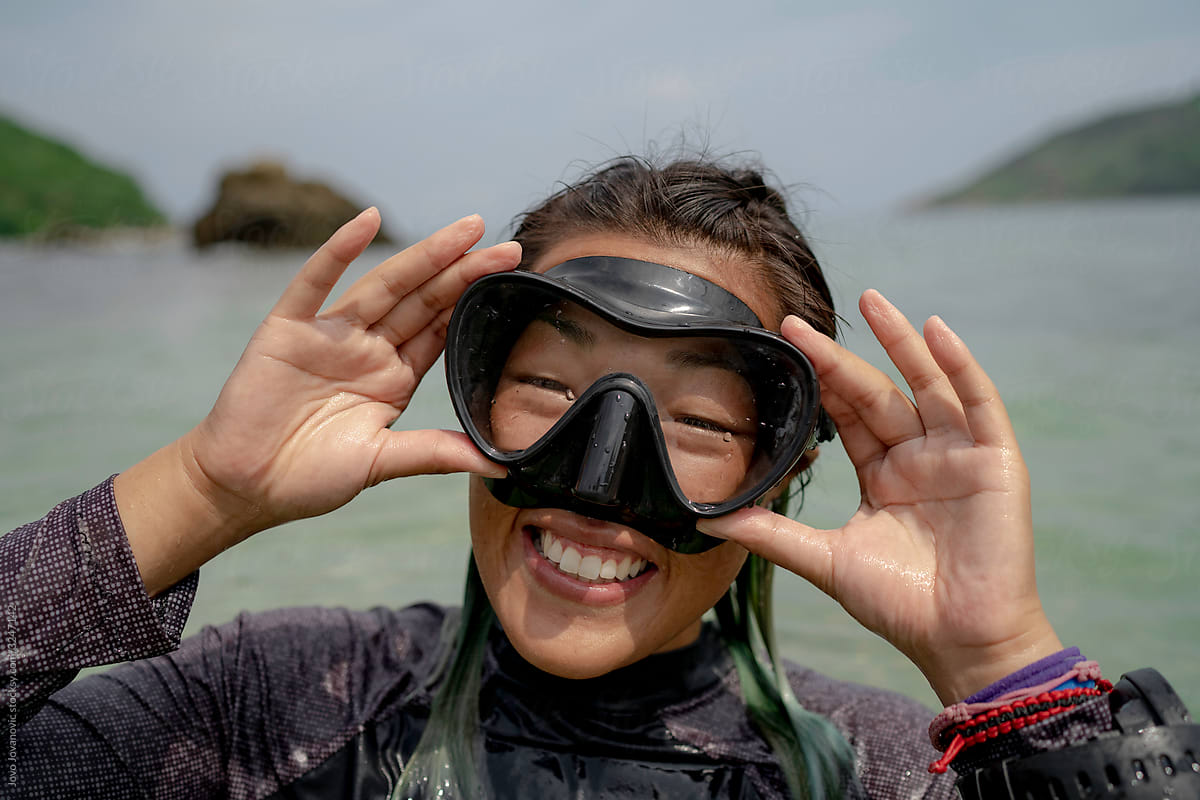 Asian diver woman smiling with her diving mask on her face